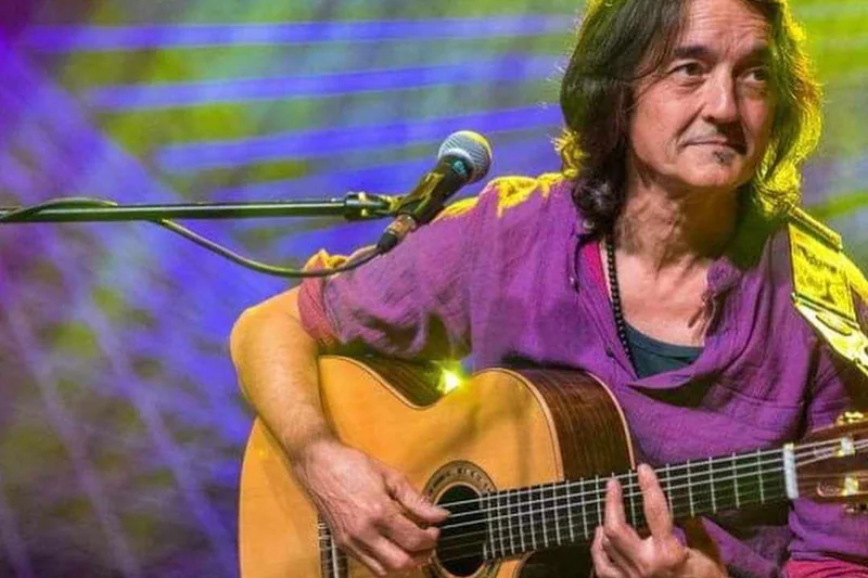 Manu en concierto con la guitarra, entre luces de colores